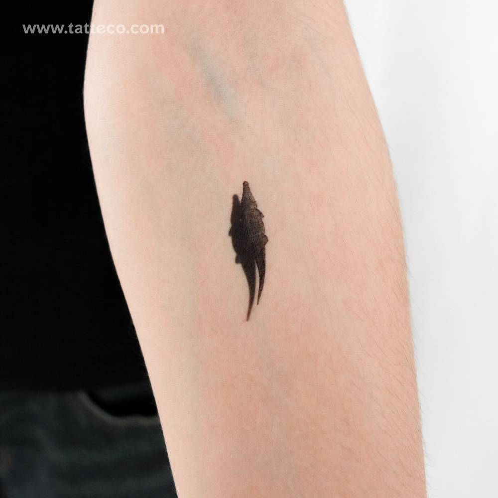 Small crocodile and shadow temporary tattoo located on the inner forearm.