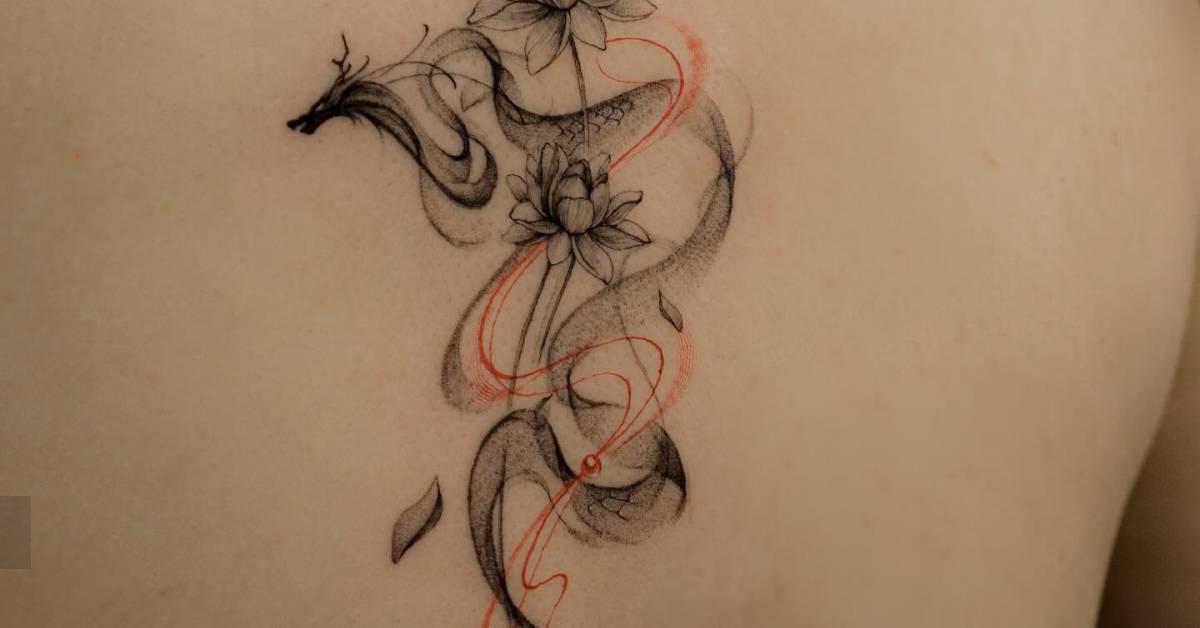 Dragon and lotus flowers tattoo located on the spine,