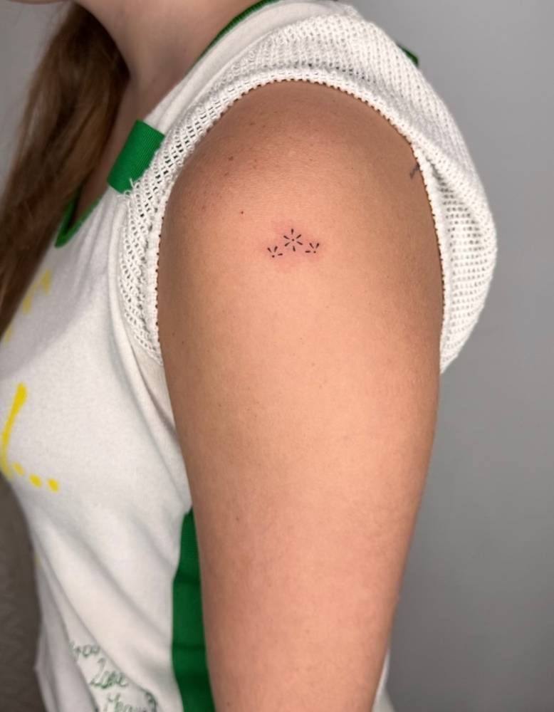 Minimalistic style ornamental tattoo located on the shoulder.