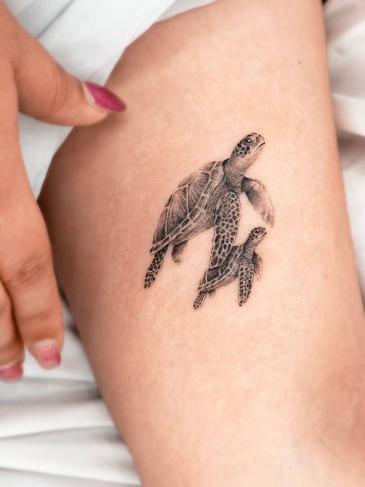 Turtle family tattooed on the inner arm, done in micro-realistic style.