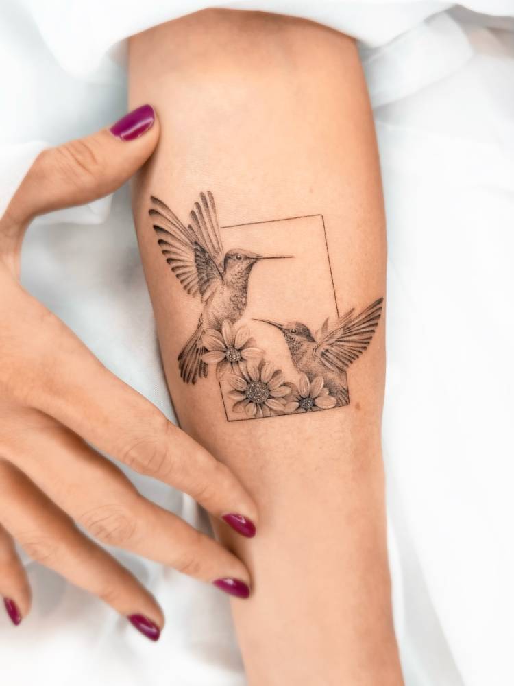 Hummingbird couple in micro-realism tattooed on the inner forearm.