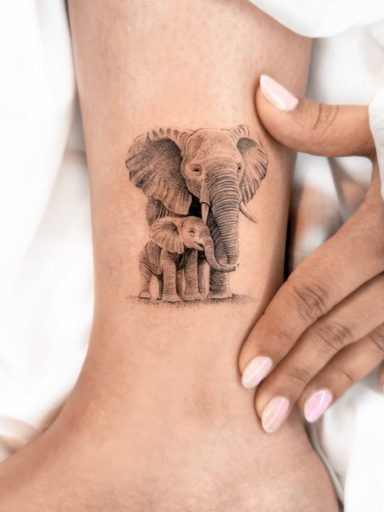 Micro-realistic elephant family tattoo placed on the ankle.
