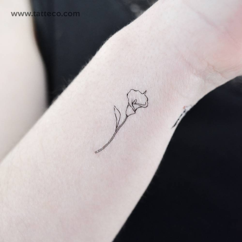 Fine line style small calla lily temporary tattoo located on the wrist.
