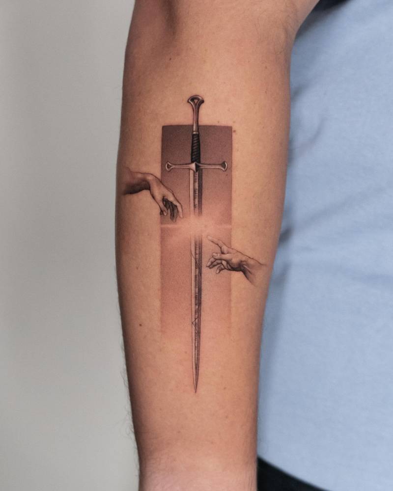 'Creation of Adam' hands and sword tattooed on the forearm.