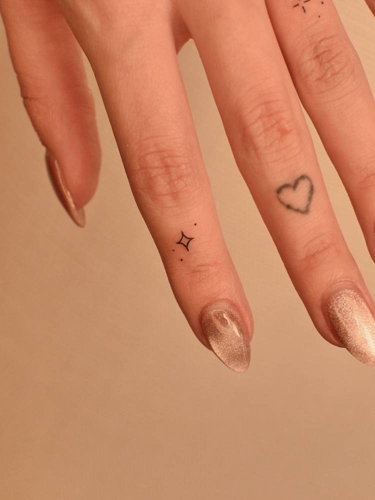 Minimalistic style micro star tattoo located on the finger.