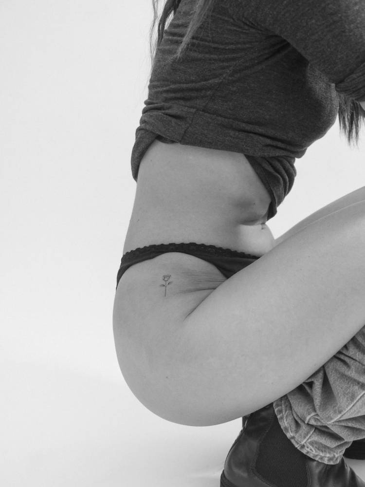 Rose in minimalistic style tattooed on the hip.