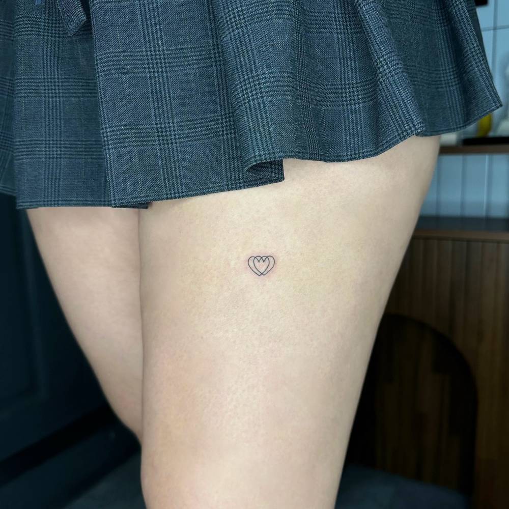 Minimalistic hearts tattoo located on the thigh.