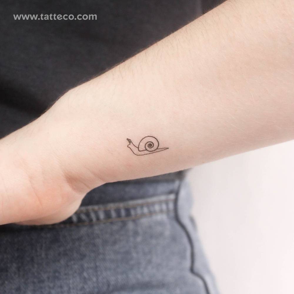 Minimalistic style snail temporary tattoo placed on the wrist.