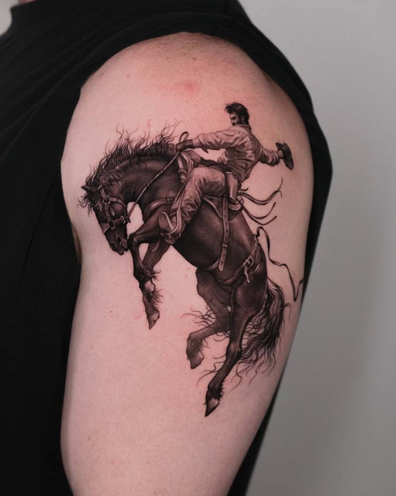 Cowboy tattoo in micro-realistic style located on the upper arm.