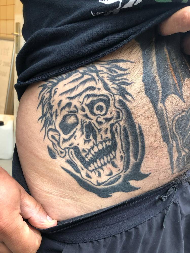 Healed zombie tattoo located on the waist, blackwork style.