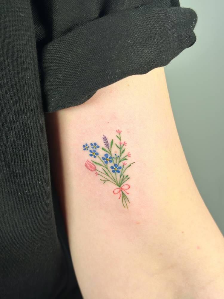 Little flower bouquet in illustrative style located on the bicep.