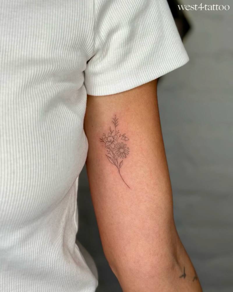 Fine line style flower bouquet tattoo located on the inner arm.