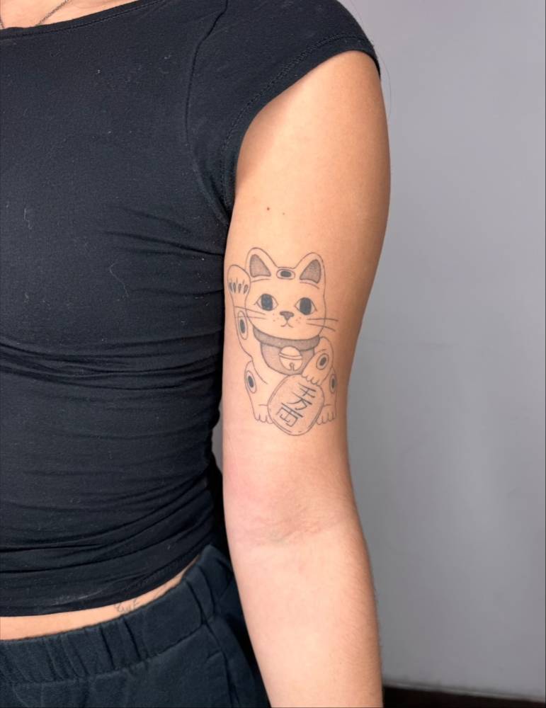 Maneki-Neko tattoo in illustrative style located on the bicep (healed).