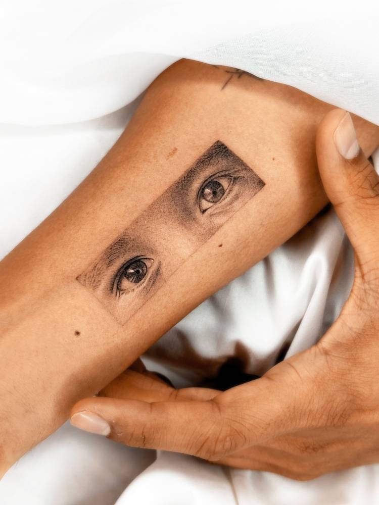 Eyes tattoo located on the inner forearm, micro-realistic style.