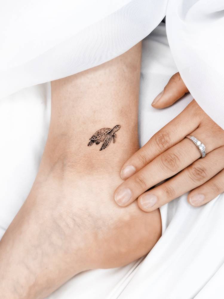 Tiny turtle in micro-realism tattooed on the ankle.