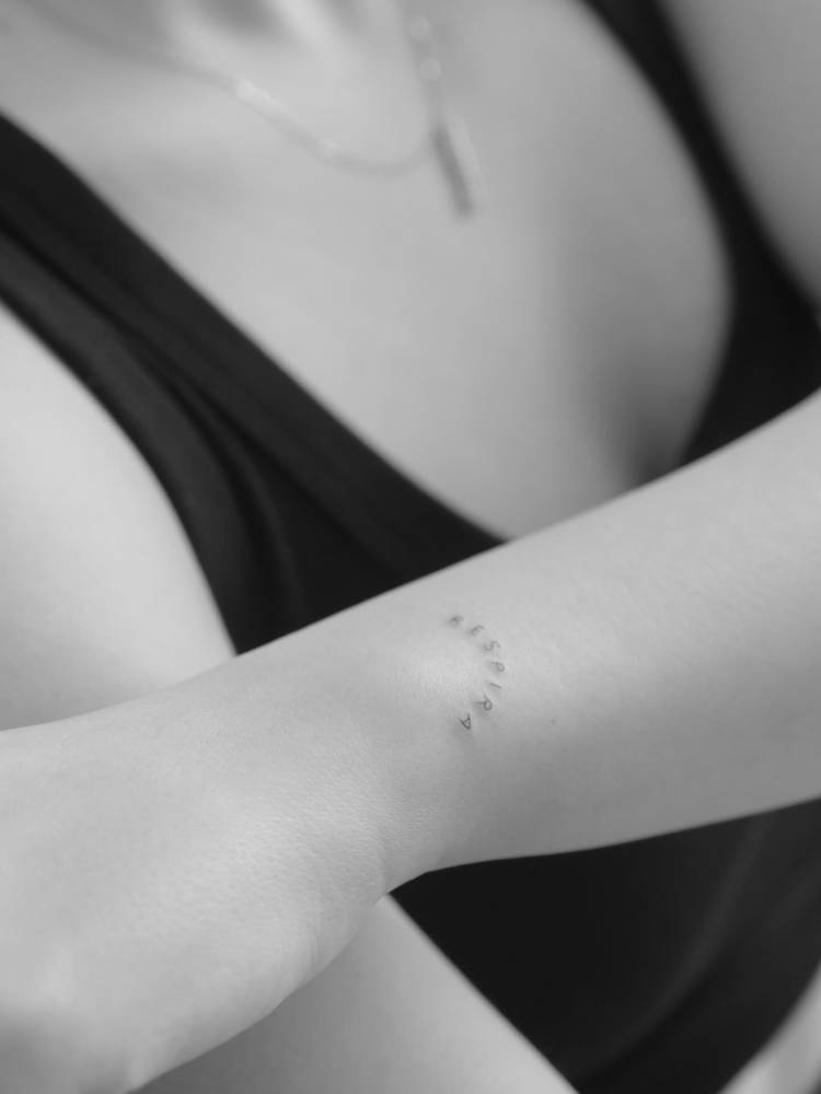 Lettering tattoo of the word "respira" located on the wrist.