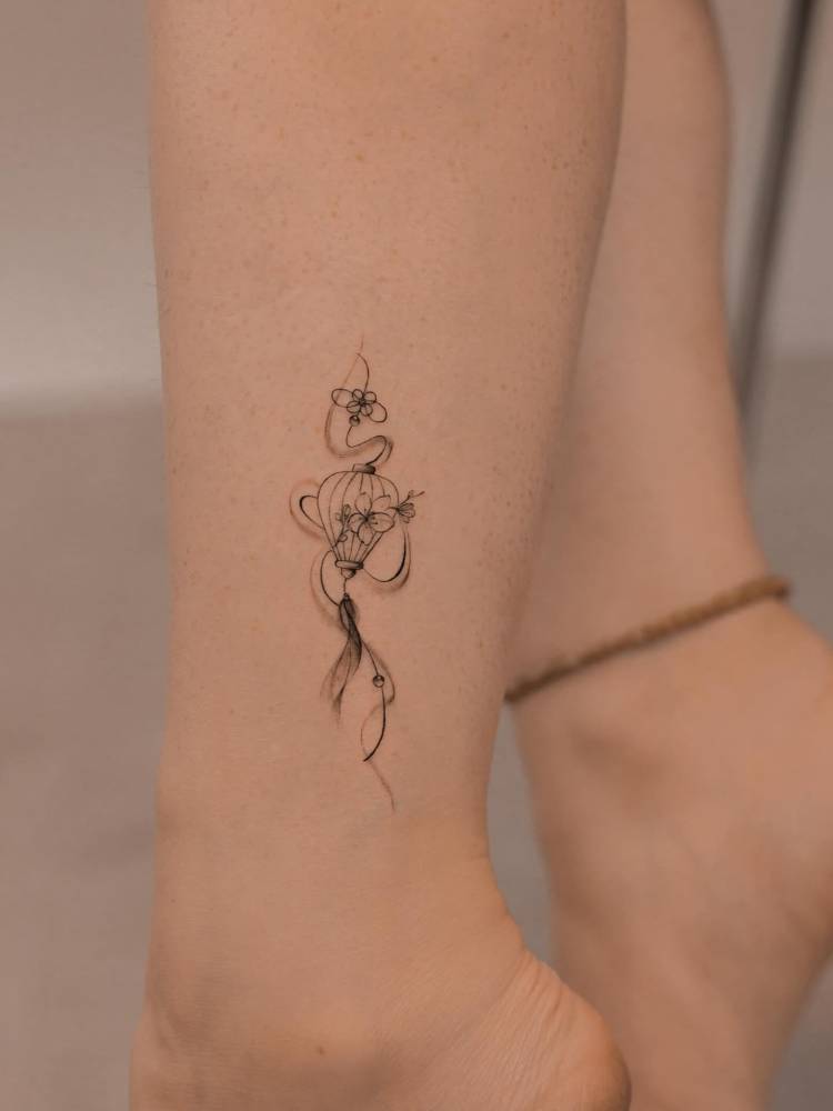 Lantern tattoo in illustrative style located on the ankle.