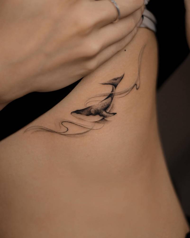 Orca tattoo in illustrative style placed on the rib.