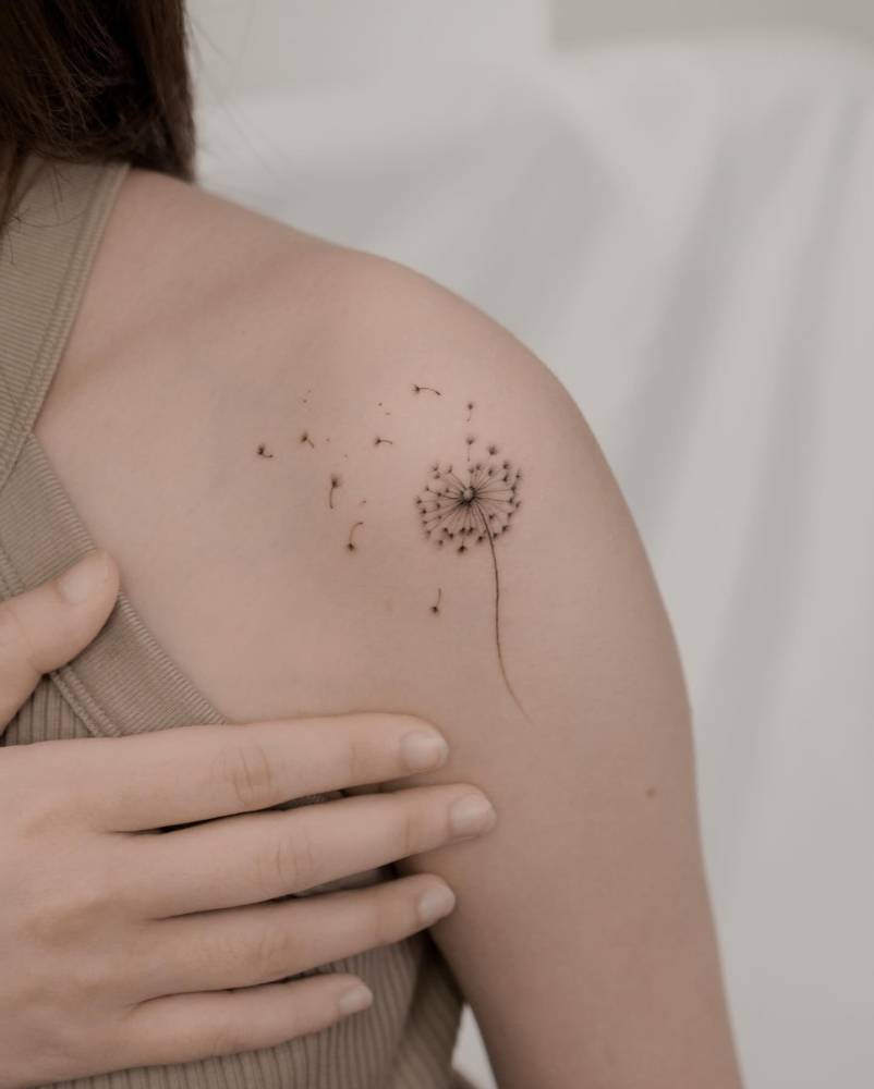 Illustrative style dandelion tattoo done on the shoulder.