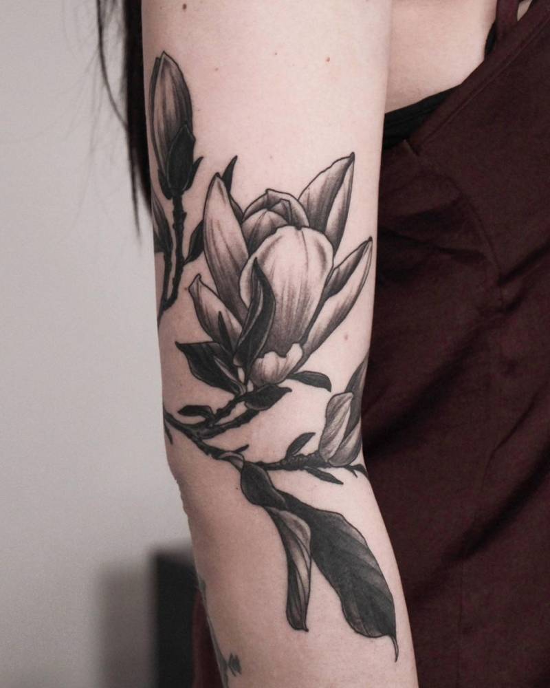 Magnolia tattoo placed on the upper arm.