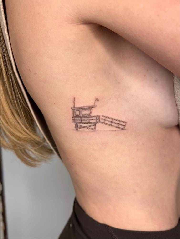 Lifeguard tower tattoo located on the side boob.