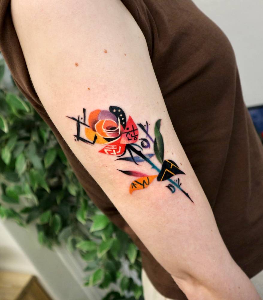 Graphic style orange rose tattoo located on the upper arm.