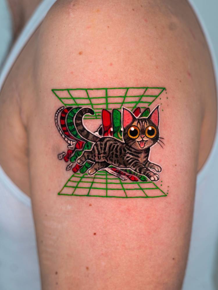 Cat tattoo in pop art style located on the upper arm.