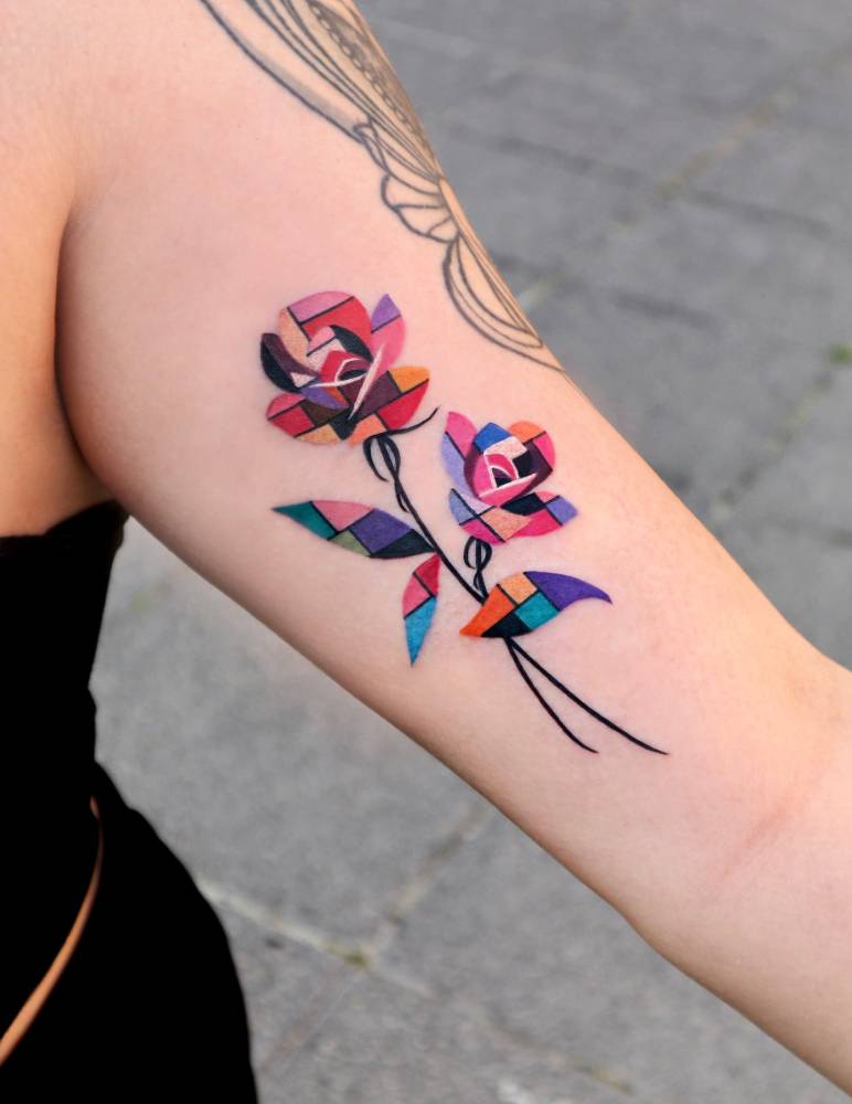 Roses tattoo in pop art style located on the inner arm.