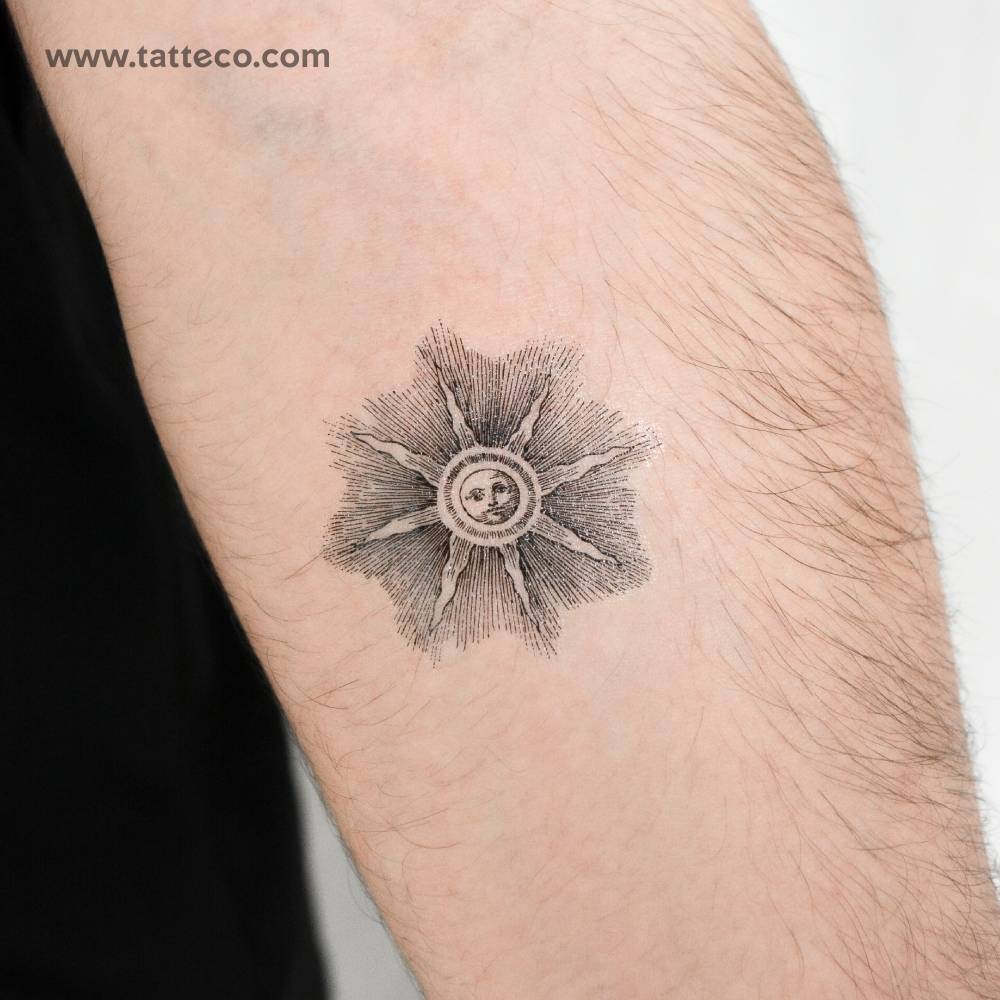 Engraving style inti sun temporary tattoo located on the inner forearm.