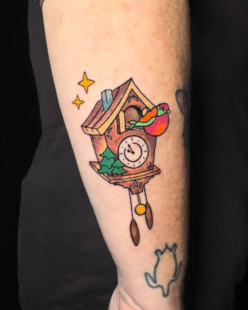 Cuckoo clock tattoo located on the wrist.