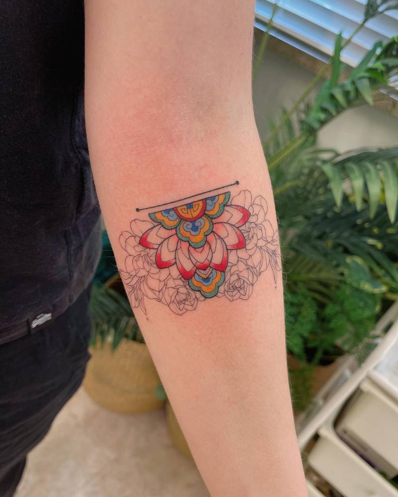 Dancheong lotus flower tattooed on the inner forearm.