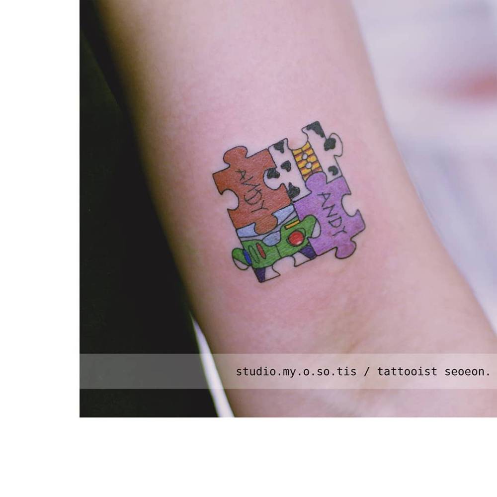 Toy Story puzzle pieces tattooed on the bicep, cartoon style.
