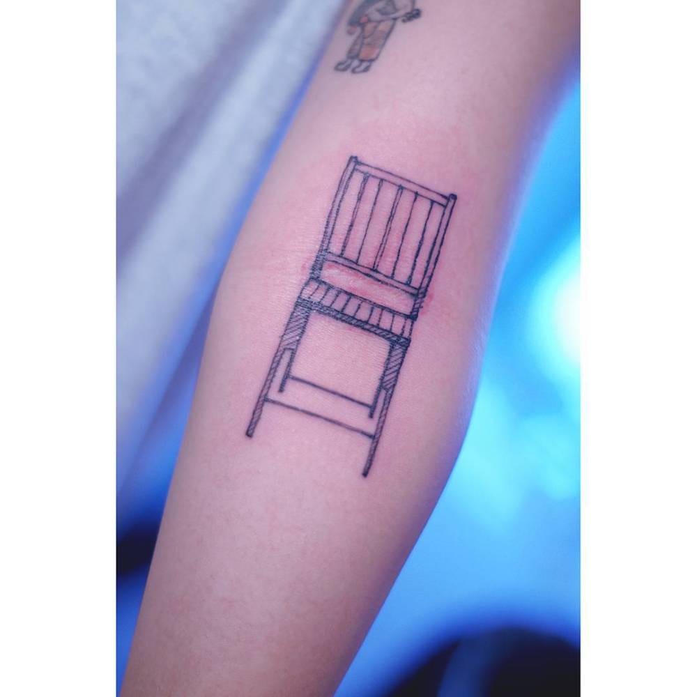 Chair tattoo in engraving style located on the inner forearm.