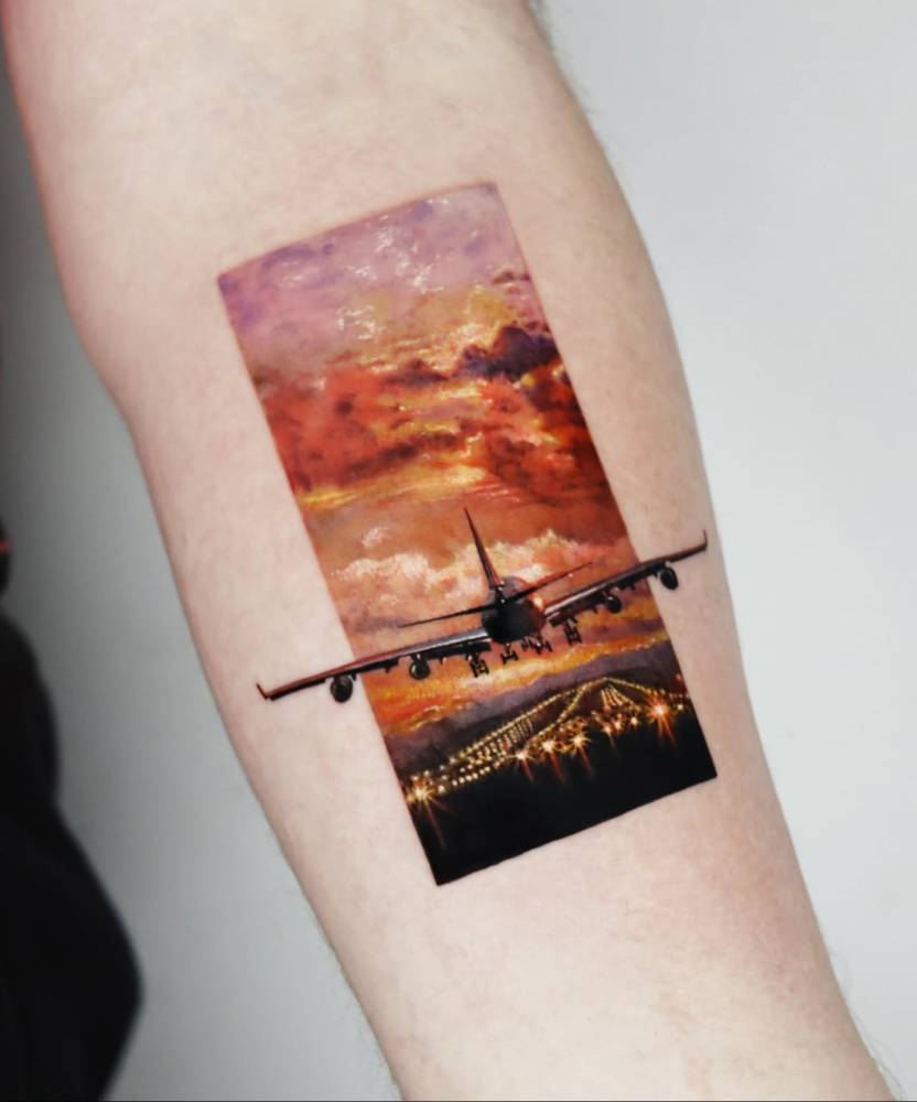 Micro-realistic style airplane tattoo located on the inner forearm.