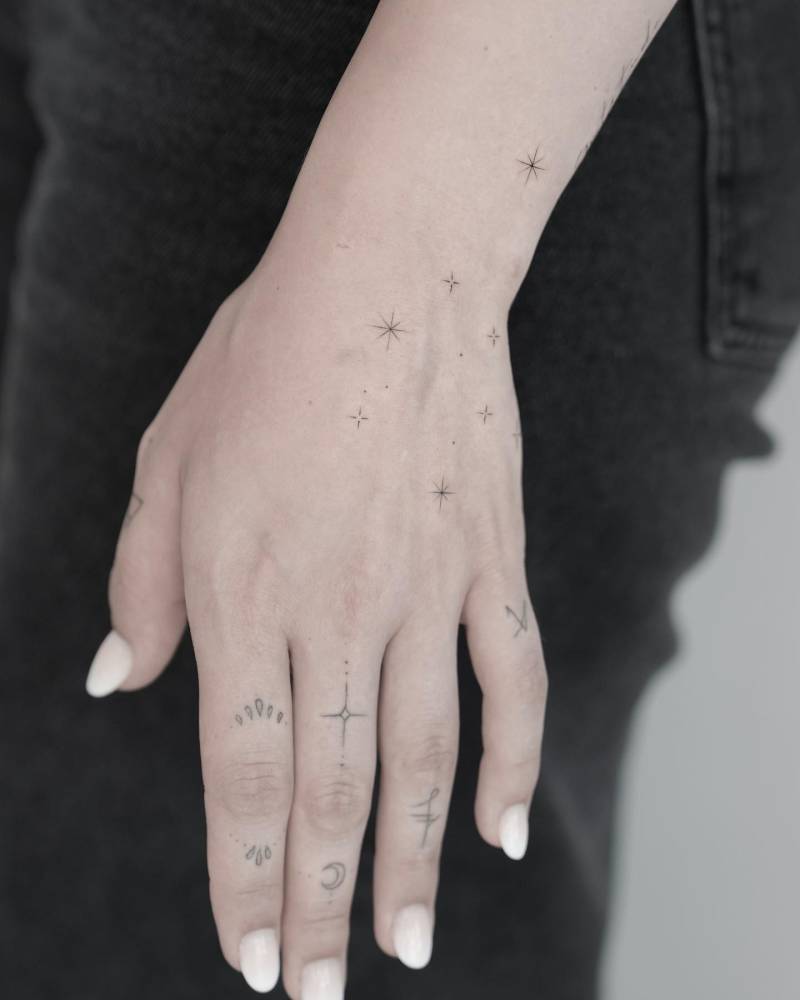 Aquarius constellation tattoo located on the wrist, minimalistic style.