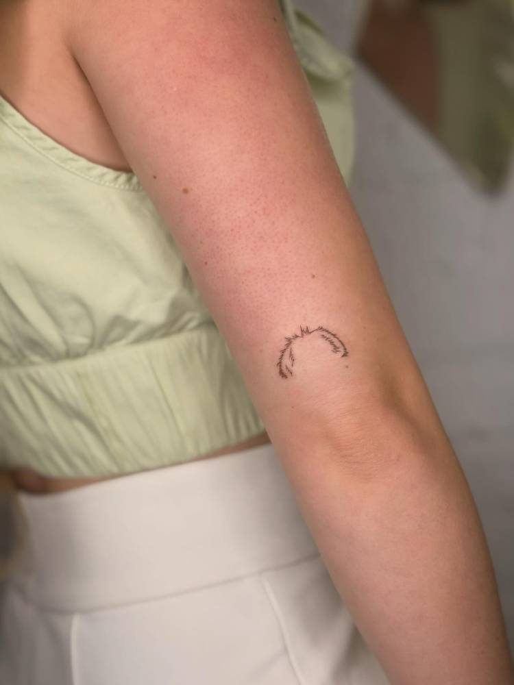Minimalistic style dog's ears tattooed on the tricep.
