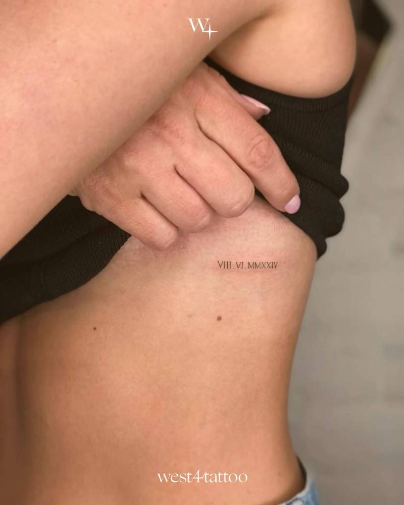 Serif font date in roman numerals tattooed on the rib.