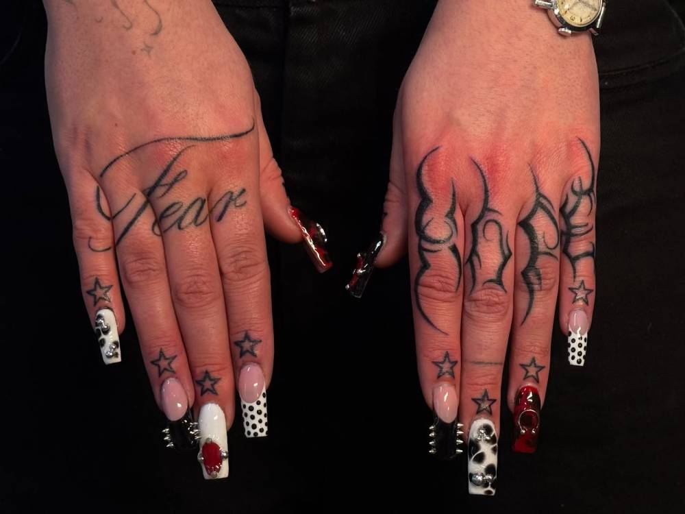 Words "fear" and "hope" with stars tattooed on the hands.