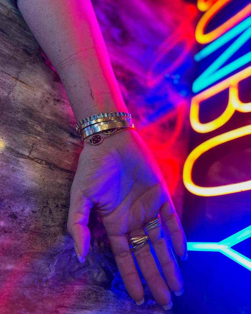 Tiny micro wave tattooed on the wrist, minimalistic style.