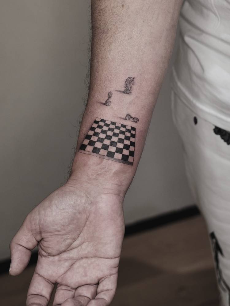 Micro-realistic style chess tattoo located on the wrist.