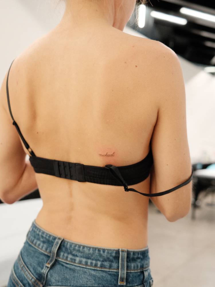 Script font name "Michael" tattooed on the back.