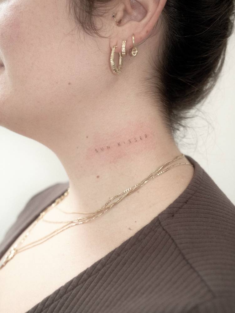 "Sunkissed" lettering tattoo located on the neck.