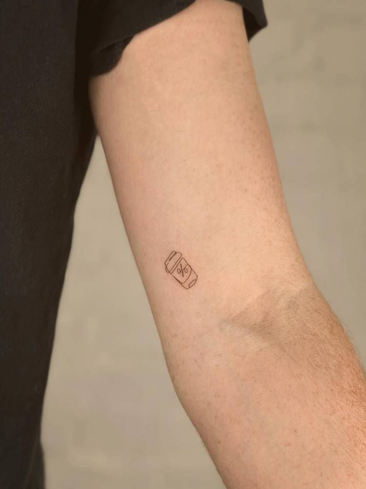 Takeaway coffee tattoo located on the inner arm, fine line style.