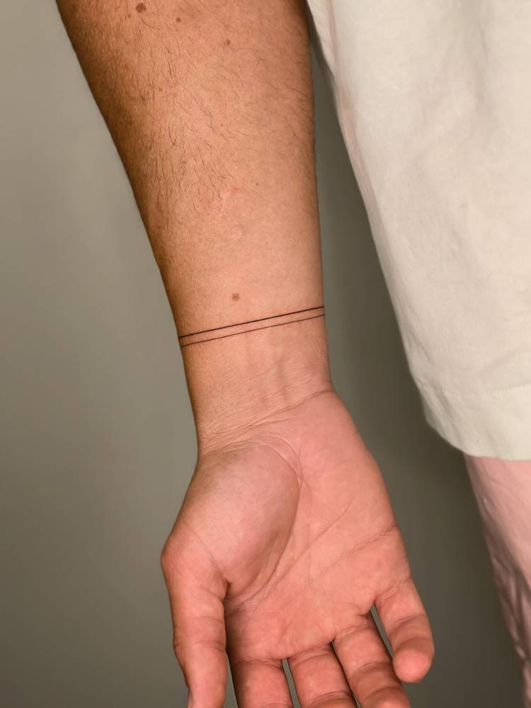 Lines wristband tattoo in minimalistic style.