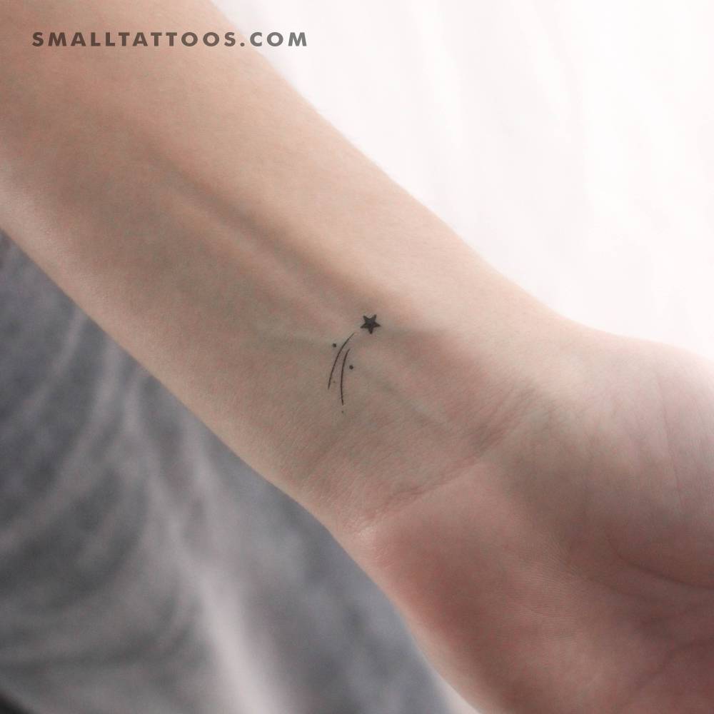 Small minimalistic shooting star temporary tattoo located on the wrist.