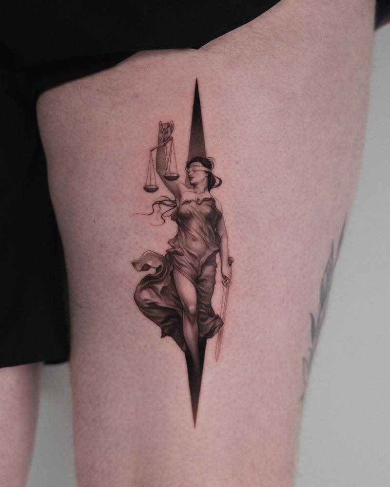Lady Justice tattoo in micro-realism located on the thigh.