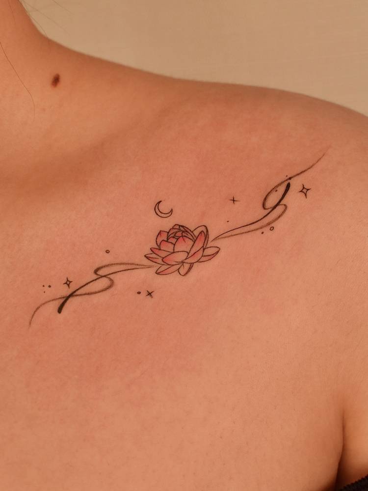 Lotus flower tattoo in illustrative style located on the collarbone.