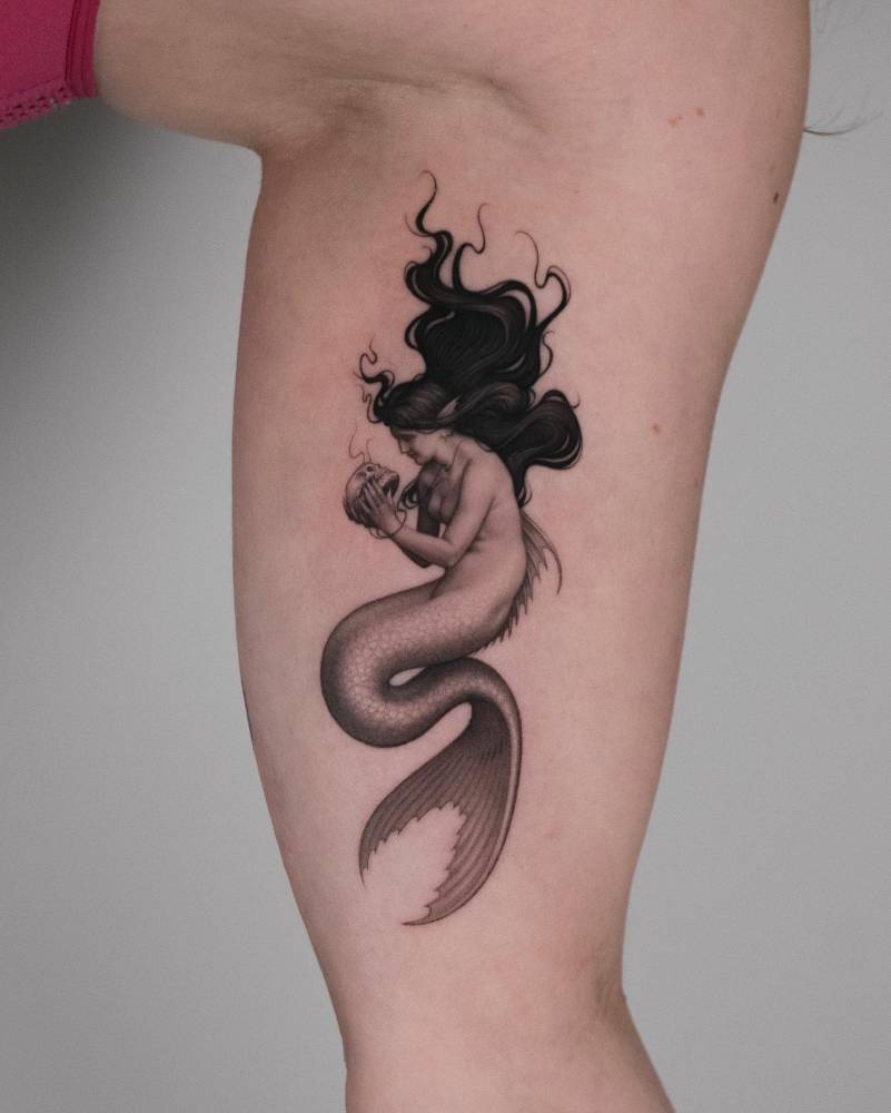 Mermaid tattoo in micro-realistic style placed on the inner forearm.