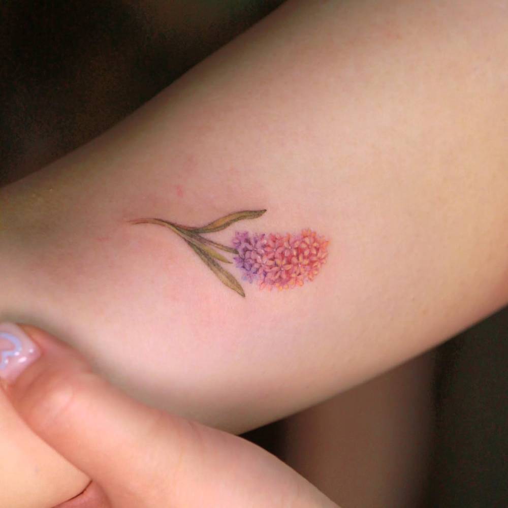 Hyacinth tattoo in watercolor style located on the inner arm.