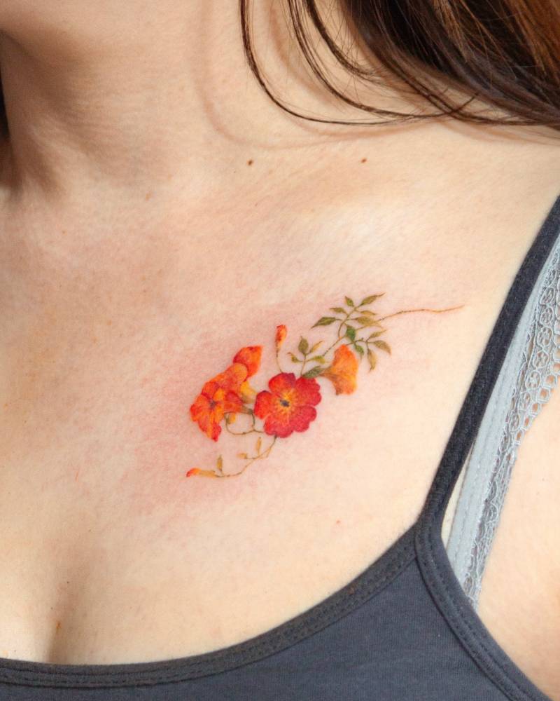Trumpet creeper tattoo in watercolor style located on the chest.
